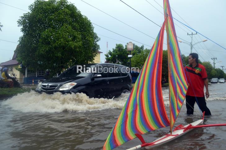 Banjir Tak Kunjung Surut, Bapak dan Anak Main 'Jung' di Depan Rumah GM Pelindo Dumai