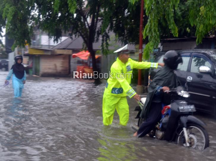 Personil Polres Dumai Dorong Kendaraan Masyarakat Mogok Ditengah Banjir