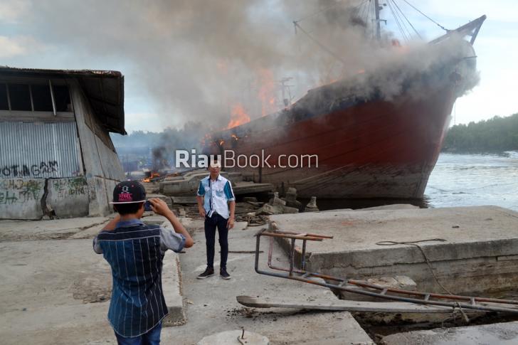 Idih... Dua Remaja di Dumai ini Malah Berfoto Dekat Kapal yang Tengah Terbakar