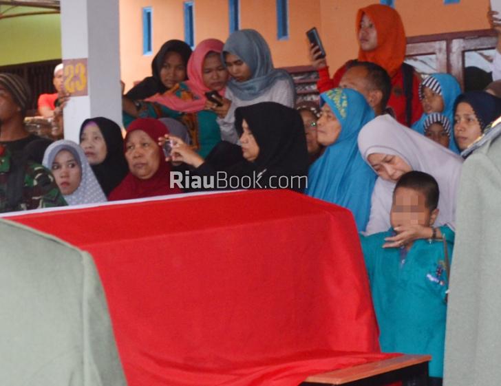 Putra Sulung Sertu Bayu Terus Berada di Sisi Peti Jenazah